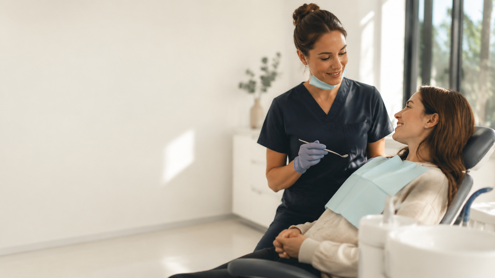 A dentist and patient in a bright, calm practice